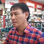 A man in a plaid shirt with short black hair